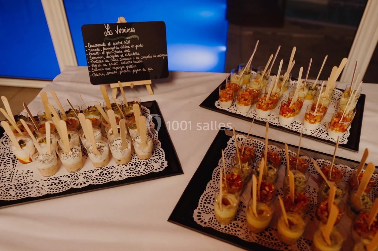 Plateaux de verrines variées présentées sur une table, accompagnées d'un tableau décrivant les ingrédients.