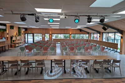 Plateau de bouchées apéritives variées disposé sur une table noire en terrasse avec vue sur un espace extérieur verdoyant.