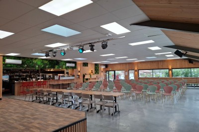 Plateau de bouchées apéritives variées disposé sur une table noire en terrasse avec vue sur un espace extérieur verdoyant.