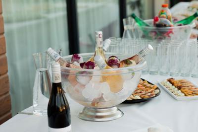 Terrasse en bois avec table dressée, chaises noires, barbecue et vue sur des maisons à colombages rouges et blanches.