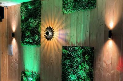 Terrasse en bois avec table dressée, chaises noires, barbecue et vue sur des maisons à colombages rouges et blanches.
