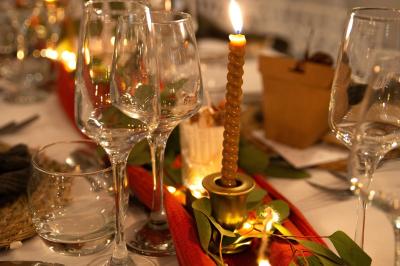 Terrasse en bois avec table dressée, chaises noires, barbecue et vue sur des maisons à colombages rouges et blanches.