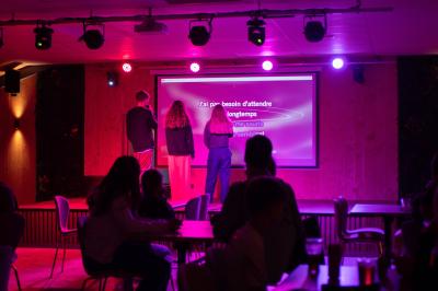 Terrasse en bois avec table dressée, chaises noires, barbecue et vue sur des maisons à colombages rouges et blanches.