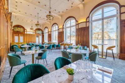 Chambre d'hôtel avec lit double, mur bleu, fauteuil rouge, table basse et décoration murale en forme de main.