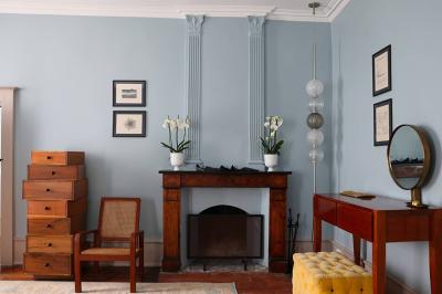 Lavabo moderne avec miroir grillagé, serviettes pliées et accessoires dans une salle de bain aux murs roses.