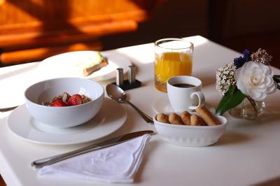 Lavabo moderne avec miroir grillagé, serviettes pliées et accessoires dans une salle de bain aux murs roses.