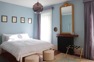 Lavabo moderne avec miroir grillagé, serviettes pliées et accessoires dans une salle de bain aux murs roses.