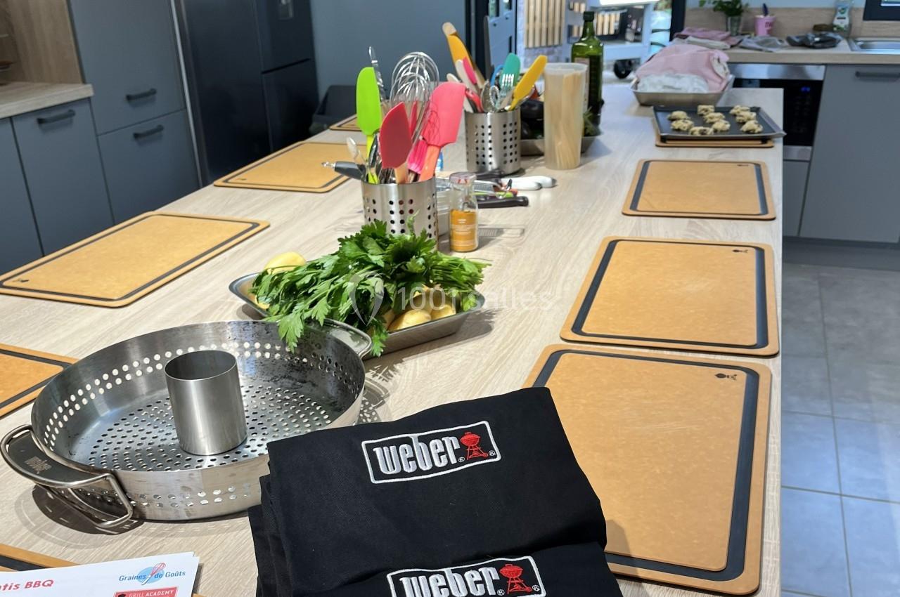 Plan de travail de cuisine avec planches à découper, ustensiles colorés, herbes fraîches et accessoires de cuisson.