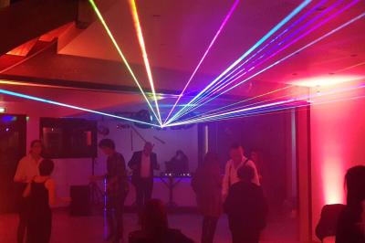 Table de mixage DJ avec platines, boutons lumineux, écran tactile et microphone sur une scène éclairée.