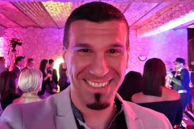 Table de mixage DJ avec platines, boutons lumineux, écran tactile et microphone sur une scène éclairée.