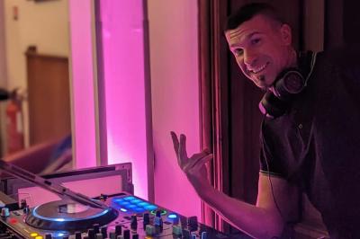 Table de mixage DJ avec platines, boutons lumineux, écran tactile et microphone sur une scène éclairée.