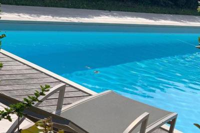 Baignoire blanche avec robinetterie moderne, serviette accrochée et produits de soin posés sur le rebord.