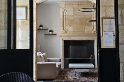 Baignoire blanche avec robinetterie moderne, serviette accrochée et produits de soin posés sur le rebord.