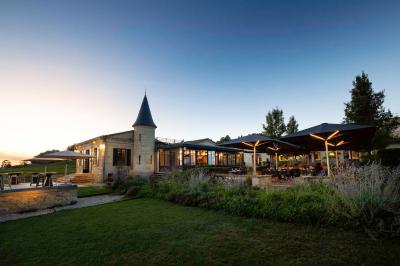 Salle de bain avec baignoire blanche, robinetterie moderne, vasque en arrière-plan et produits de toilette posés.