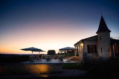 Salle de bain avec baignoire blanche, robinetterie moderne, vasque en arrière-plan et produits de toilette posés.