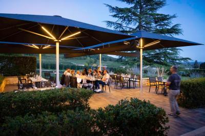 Salle de bain avec baignoire blanche, robinetterie moderne, vasque en arrière-plan et produits de toilette posés.