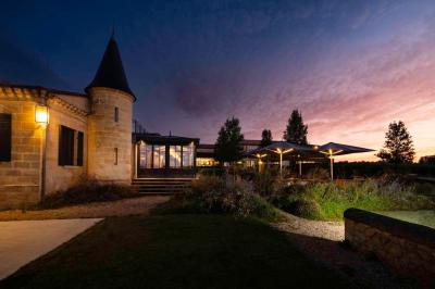 Salle de bain avec baignoire blanche, robinetterie moderne, vasque en arrière-plan et produits de toilette posés.