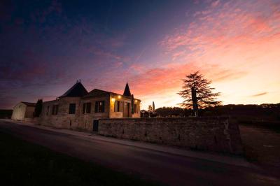 Salle de bain avec baignoire blanche, robinetterie moderne, vasque en arrière-plan et produits de toilette posés.