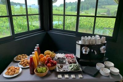 Salle de bain avec baignoire blanche, robinetterie moderne, vasque en arrière-plan et produits de toilette posés.