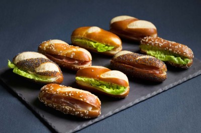 Plateau de bouchées variées comprenant mini-burgers, wraps, brochettes et amuse-bouches garnis.