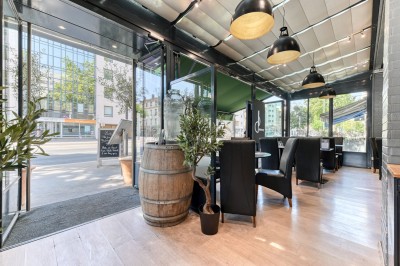 Miniature Location salle Lyon 7 (Rhône) - Brasserie Debourg #56 Comptoir de bar moderne avec revêtement en bois, étagères de bouteilles, tables hautes et sol en carreaux décoratifs.