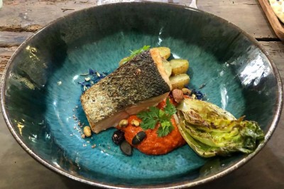 Assiette de dessert composée de meringues, éclats de caramel, feuilles de menthe et miettes de biscuit noir.