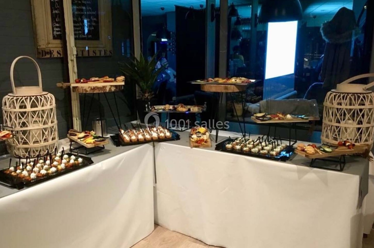 Buffet de présentation avec divers amuse-bouches disposés sur des plateaux, entourés de décorations en osier.