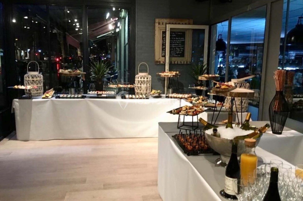 Buffet de réception avec tables garnies de plats variés, bouteilles de vin, verres et décoration élégante.