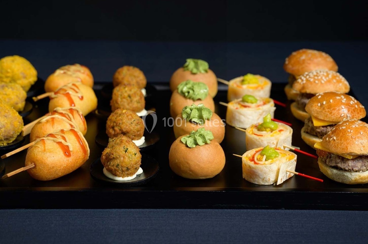 Plateau de bouchées variées comprenant mini-burgers, wraps, brochettes et amuse-bouches garnis.