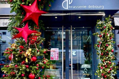 Plateau de charcuterie avec fromage et légumes en premier plan, paniers de pain et quiches en arrière-plan.