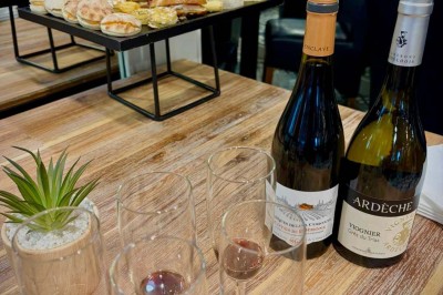 Plateau de charcuterie avec fromage et légumes en premier plan, paniers de pain et quiches en arrière-plan.