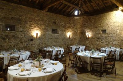 Vue d'un château en pierre entouré d'arbres et d'une pelouse bien entretenue sous un ciel dégagé.