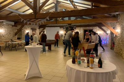 Salle de réception décorée avec des tables dressées, nappes blanches, bouquets de roses et chaises blanches.