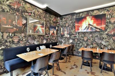 Un boucher découpe un morceau de viande rouge sur une planche blanche avec un couteau.