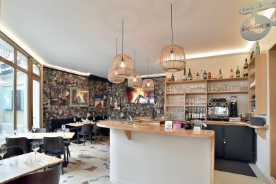 Un boucher découpe un morceau de viande rouge sur une planche blanche avec un couteau.