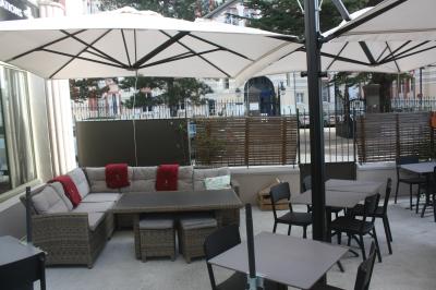 Un boucher découpe un morceau de viande rouge sur une planche blanche avec un couteau.