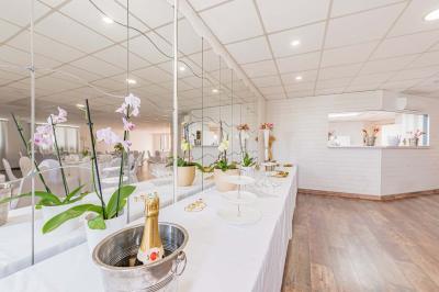 Chambre lumineuse avec lit double, tables de chevet, lampes, sol en bois clair et fenêtres donnant sur l'extérieur.