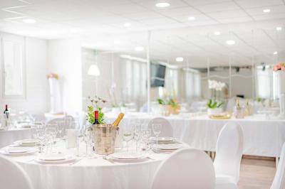 Chambre lumineuse avec lit double, tables de chevet, lampes, sol en bois clair et fenêtres donnant sur l'extérieur.