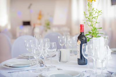 Chambre lumineuse avec lit double, tables de chevet, lampes, sol en bois clair et fenêtres donnant sur l'extérieur.