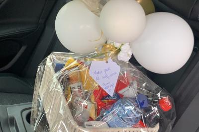 SUV noir décoré d'un bouquet de fleurs sur le capot, stationné sur un parking entouré de végétation.