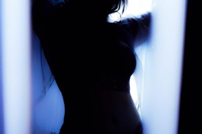 Voiture sportive bleue stationnée sur une place pavée devant un monument en bronze et des bâtiments historiques.