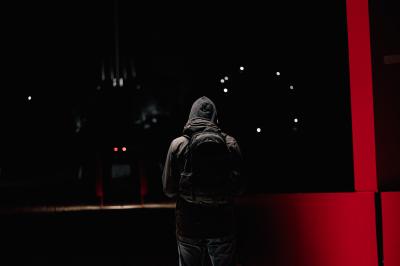 Voiture sportive bleue stationnée sur une place pavée devant un monument en bronze et des bâtiments historiques.