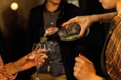 Salle de restaurant chaleureuse avec mobilier en bois, grandes fenêtres et éclairage suspendu.