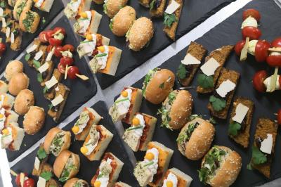 Plateau de bouchées apéritives variées comprenant mini-burgers, brochettes, verrines et cubes de pain doré.