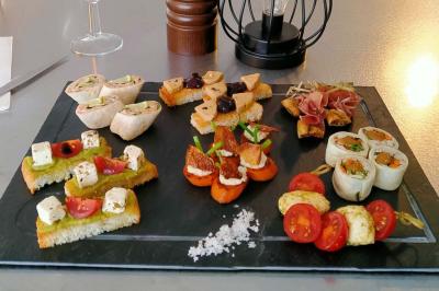 Plateau de bouchées apéritives variées comprenant mini-burgers, brochettes, verrines et cubes de pain doré.