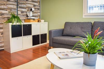 Bureau partagé avec plantes, carte posée sur un support en bois, et personnes travaillant en arrière-plan.