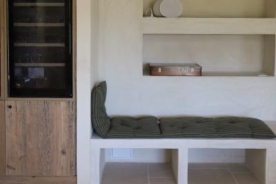 Un couple en tenue de mariage marche main dans la main dans un vignoble, la mariée levant un bouquet.