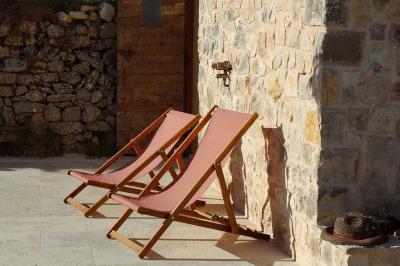 Un couple en tenue de mariage marche main dans la main dans un vignoble, la mariée levant un bouquet.