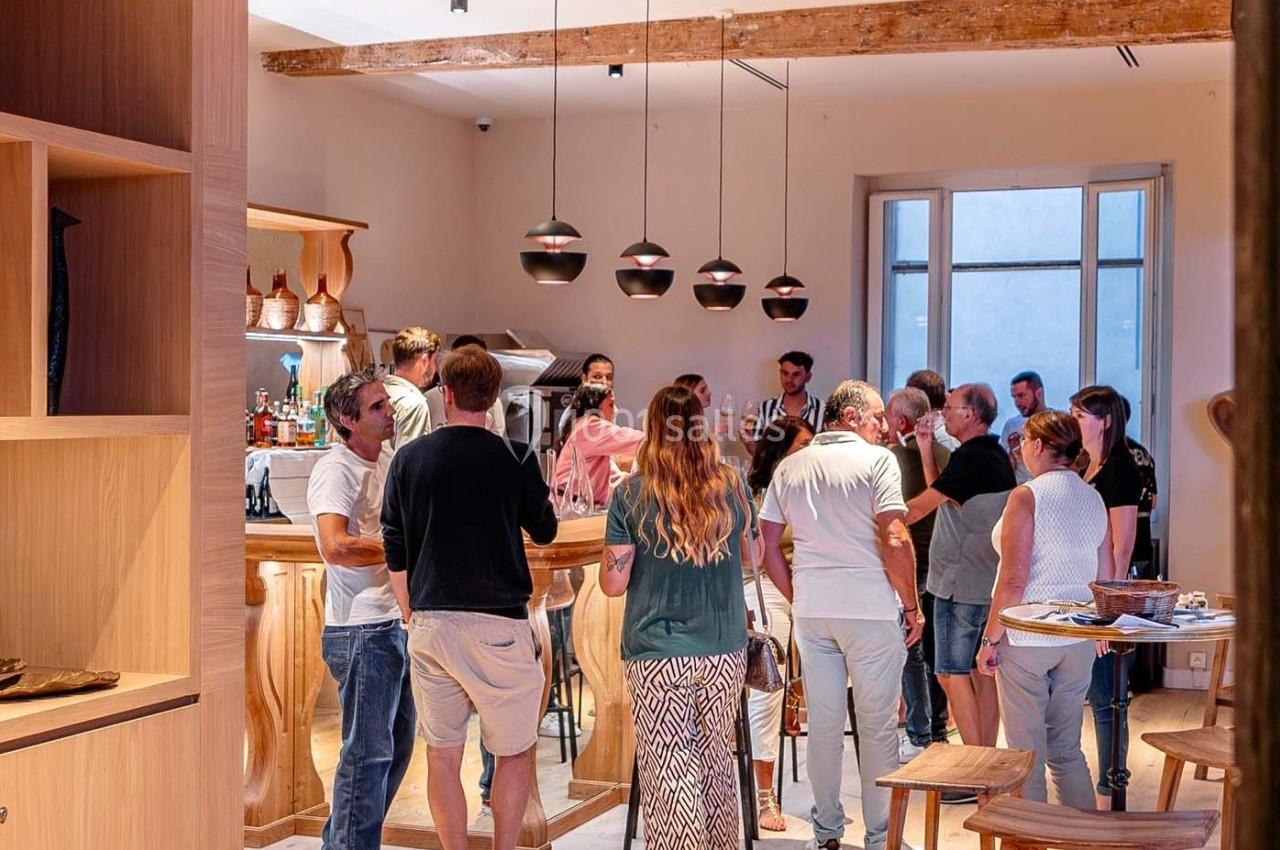 Groupe de personnes discutant dans un bar à l'intérieur d'une pièce lumineuse avec des éléments en bois.