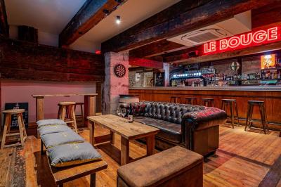 Seau à champagne avec bouteilles et deux verres sur une table en marbre, fauteuil en cuir en arrière-plan.